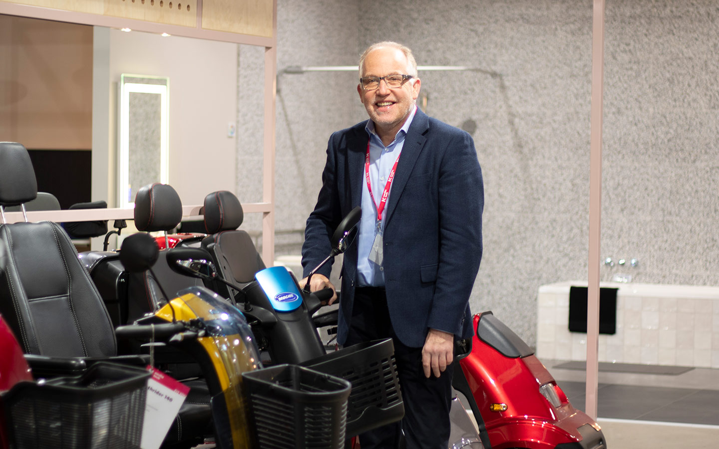 NovitaTech team member with mobility scooters in the Hindmarsh showroom