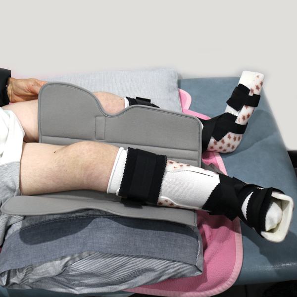 Lay it flat underneath your knee. Widest part of the brace should be under your thigh.