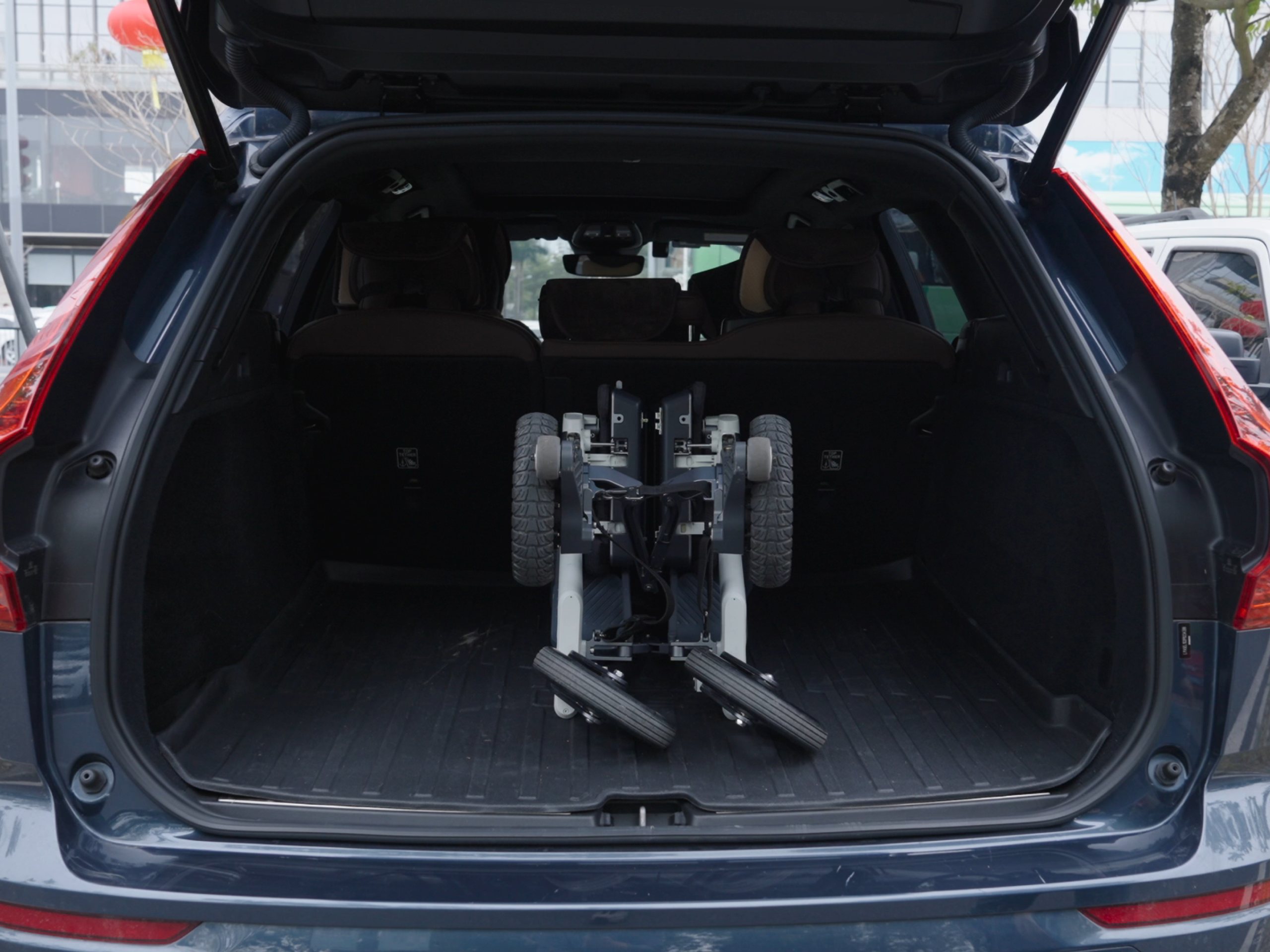 Roamate electric walker wheelchair folded upright in the boot of an SUV